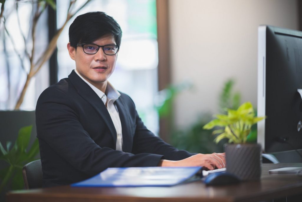 portrait of businessman in co-working space, handsome CEO smiling in suit