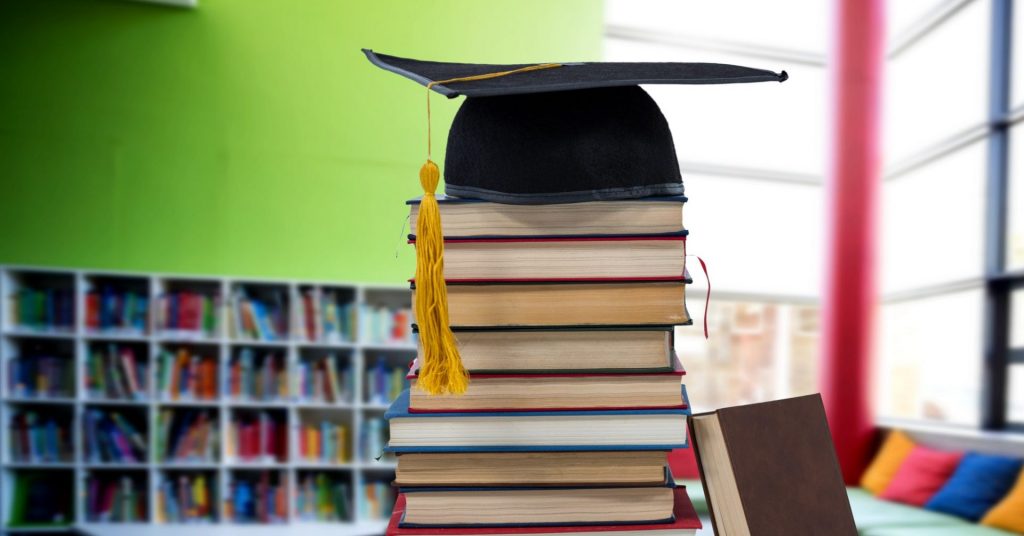 Books and graduation hat in education library | Winter-Dent Books and graduation hat in education library